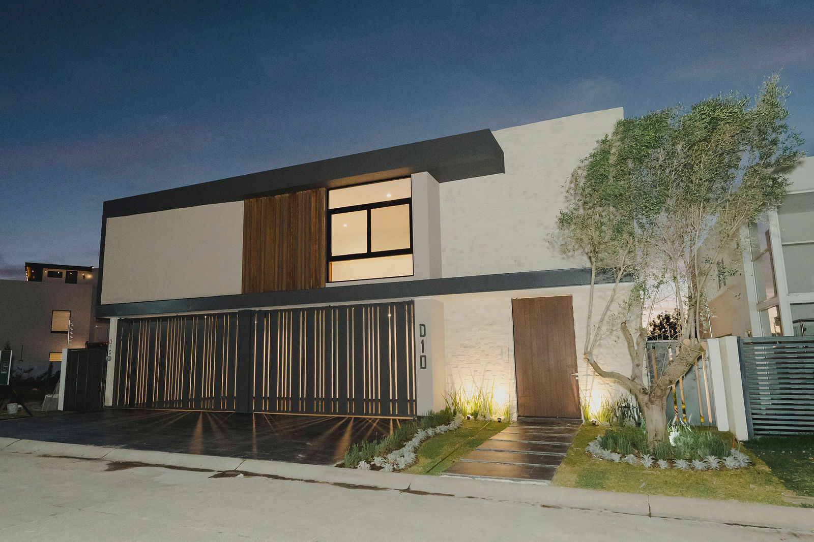 Fachada de residencia iluminada al anochecer