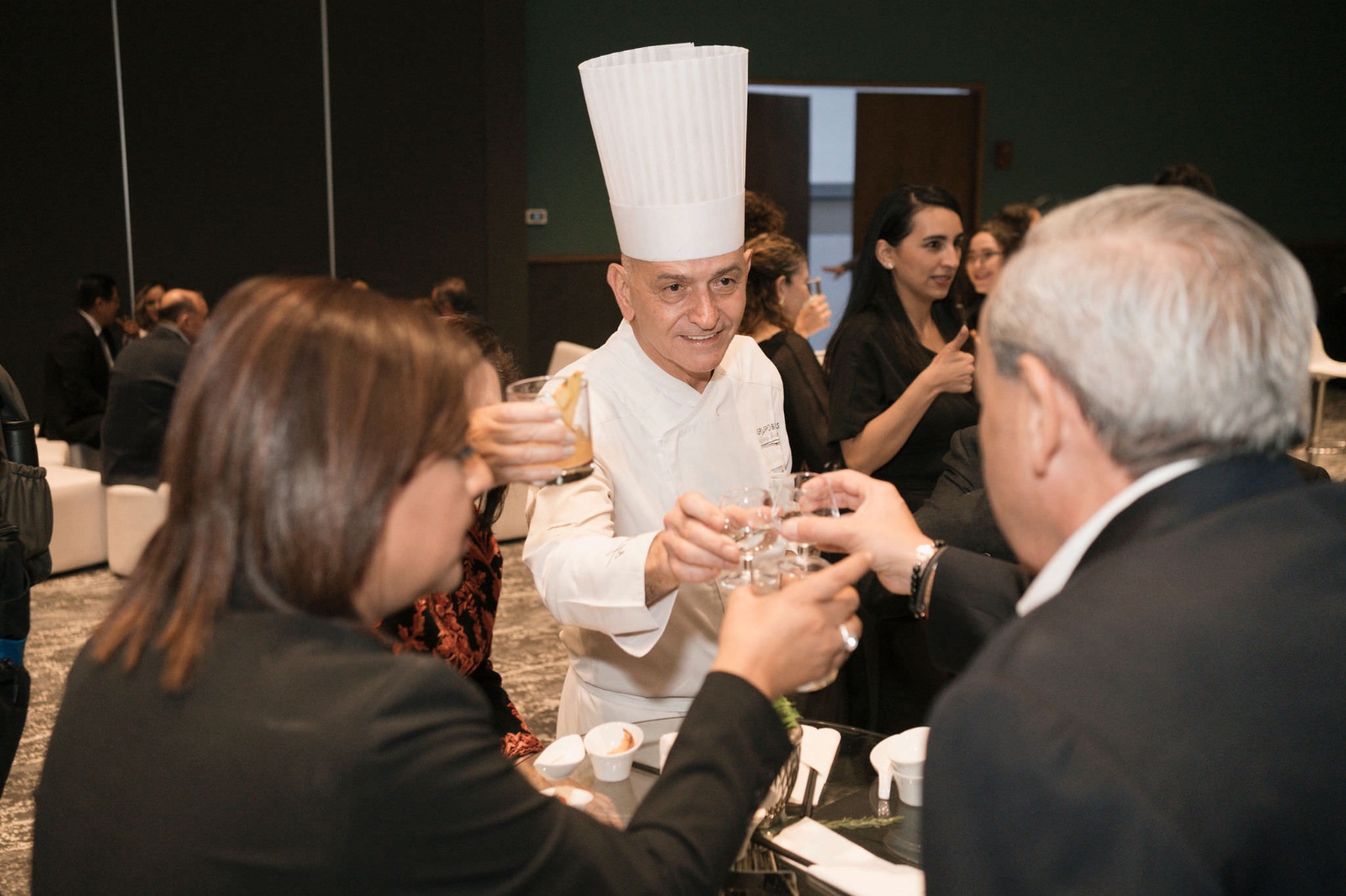 Chef brindando con invitados en un evento corporativo