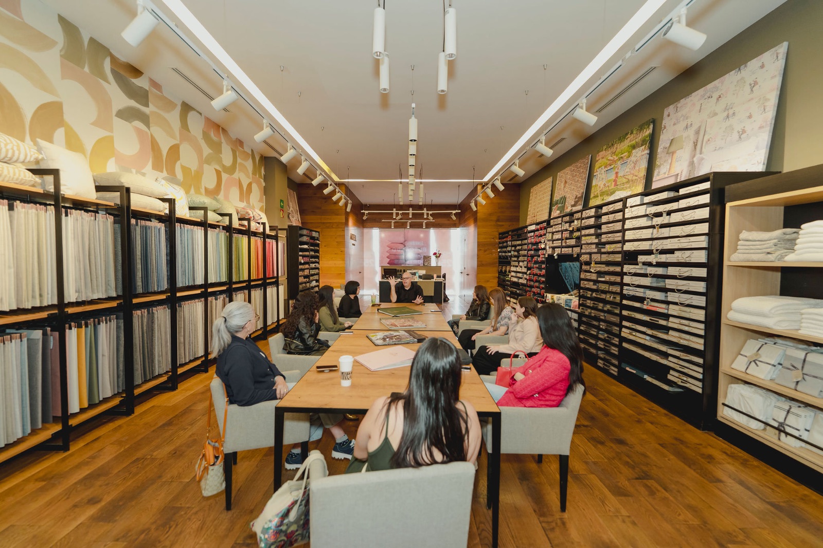Sala de showroom con muestras de materiales, personas reunidas en junta
